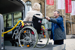 Rollstuhlfahrerin vor der Stadthalle
